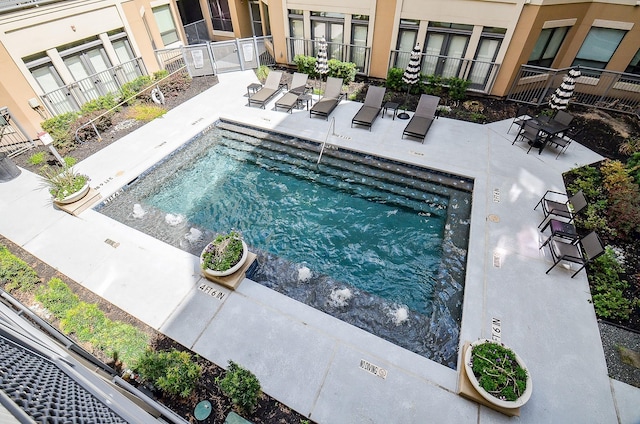 community pool with fence and a patio
