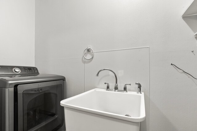 laundry room featuring laundry area, a sink, and washer / clothes dryer