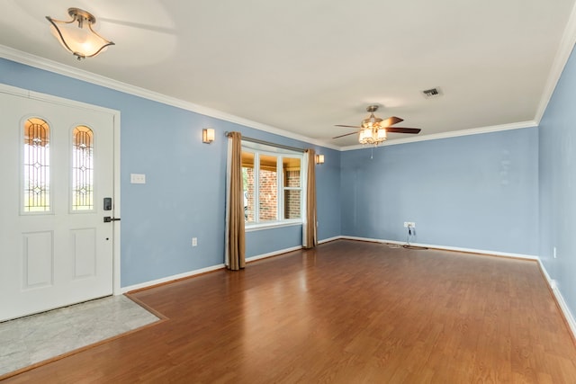 foyer entrance featuring crown molding, a ceiling fan, baseboards, wood finished floors, and visible vents