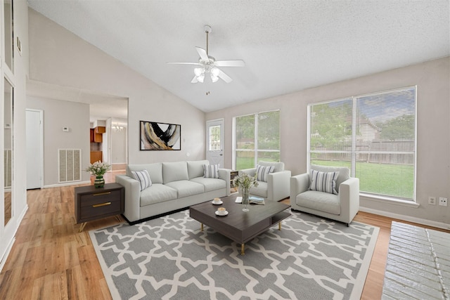 living room featuring visible vents, a ceiling fan, baseboards, and light wood-type flooring