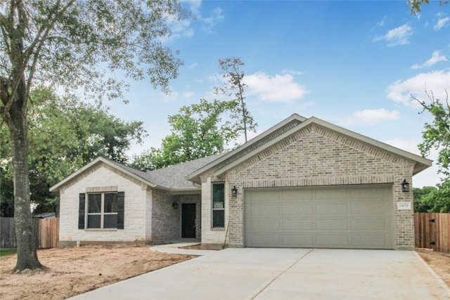 single story home featuring fence, an attached garage, concrete driveway, and brick siding