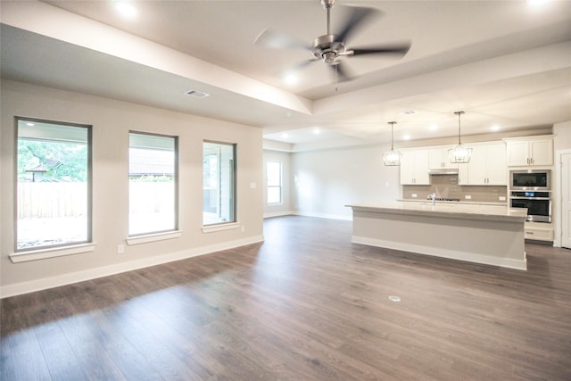 unfurnished living room featuring dark wood-style flooring, ceiling fan, recessed lighting, baseboards, and visible vents