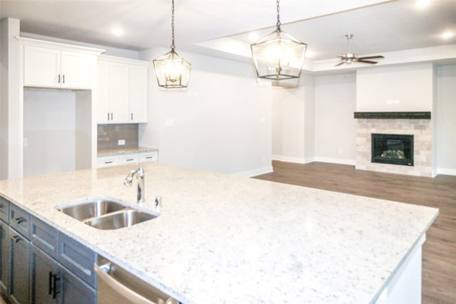 kitchen with a sink, white cabinetry, ceiling fan, and wood finished floors