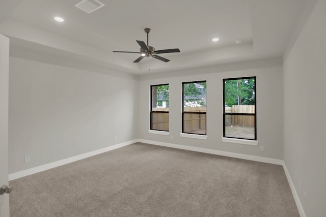 spare room with carpet floors, recessed lighting, visible vents, and a raised ceiling