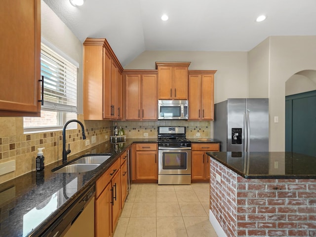3009 Kurth Canyon Ct, League City, TX 77573 - kitchen featuring stainless steel appliances, a sink, brown cabinets, dark stone countertops, and backsplash