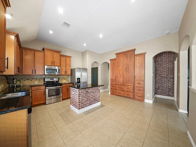 3009 Kurth Canyon Ct, League City, TX 77573 - kitchen featuring appliances with stainless steel finishes, a sink, arched walkways, decorative backsplash, and light tile patterned flooring