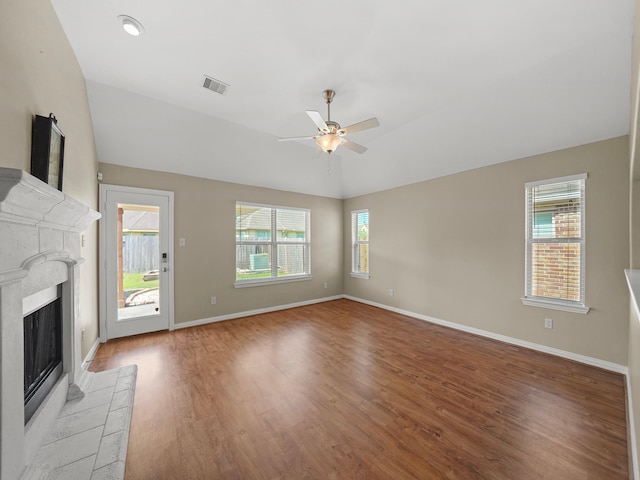 3009 Kurth Canyon Ct, League City, TX 77573 - unfurnished living room featuring a ceiling fan, a tiled fireplace, light wood finished floors, baseboards, and lofted ceiling
