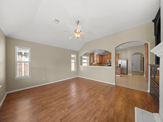3009 Kurth Canyon Ct, League City, TX 77573 - unfurnished living room with ceiling fan, healthy amount of natural light, lofted ceiling, light wood-style flooring, and baseboards
