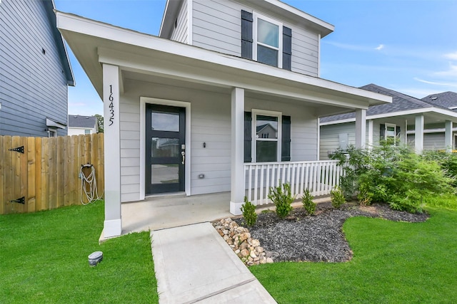 16435 Valerie Marie Pl, Conroe, TX 77306 - doorway to property featuring a yard, covered porch, and fence