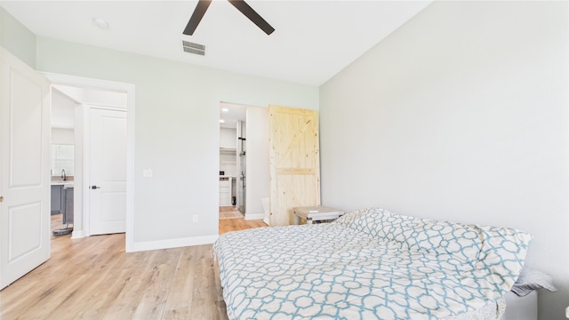 bedroom with ceiling fan, visible vents, baseboards, a spacious closet, and light wood-style floors