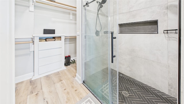bathroom with a shower stall and wood finished floors