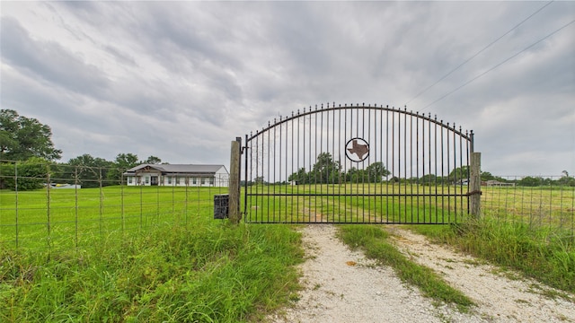 view of gate with fence and a yard