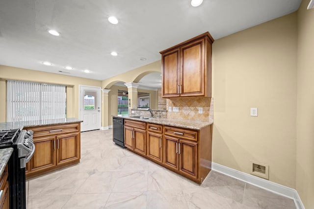 kitchen featuring black dishwasher, stainless steel gas range, ornate columns, arched walkways, and a sink