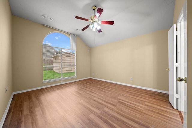 unfurnished room with light wood-style floors, a ceiling fan, vaulted ceiling, and visible vents