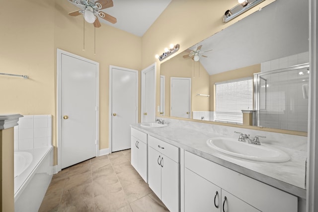 bathroom featuring ceiling fan, a sink, double vanity, lofted ceiling, and a bath