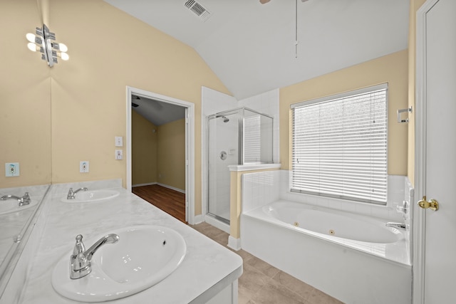bathroom featuring visible vents, a sink, lofted ceiling, and a stall shower