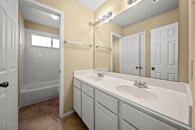 bathroom with double vanity, toilet, a sink, and marble finish floor
