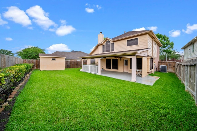 back of house featuring an outdoor structure, central AC, a fenced backyard, a chimney, and a patio area