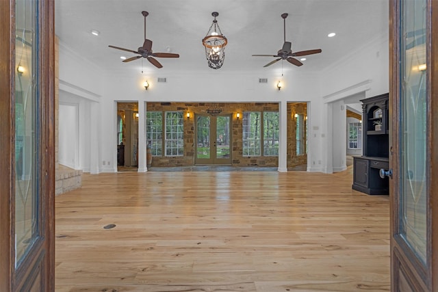 unfurnished living room with crown molding, a ceiling fan, and french doors