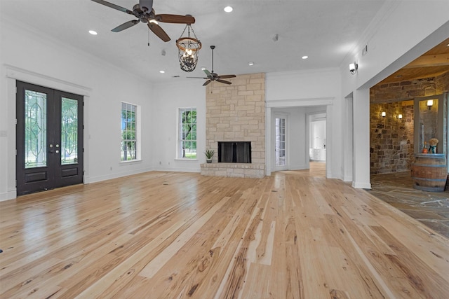 unfurnished living room with light wood-style floors, crown molding, ceiling fan, and a healthy amount of sunlight