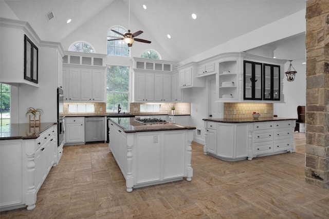 kitchen with ceiling fan, appliances with stainless steel finishes, a center island, white cabinetry, and visible vents