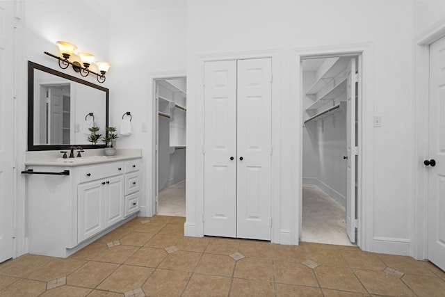 full bathroom featuring vanity, crown molding, tile patterned flooring, and a spacious closet