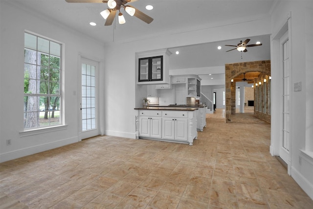 kitchen with ceiling fan, dark countertops, baseboards, ornamental molding, and recessed lighting