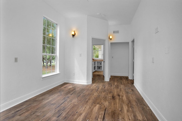 interior space featuring visible vents, dark wood finished floors, baseboards, and a healthy amount of sunlight