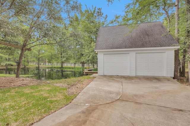 detached garage with fence and a water view