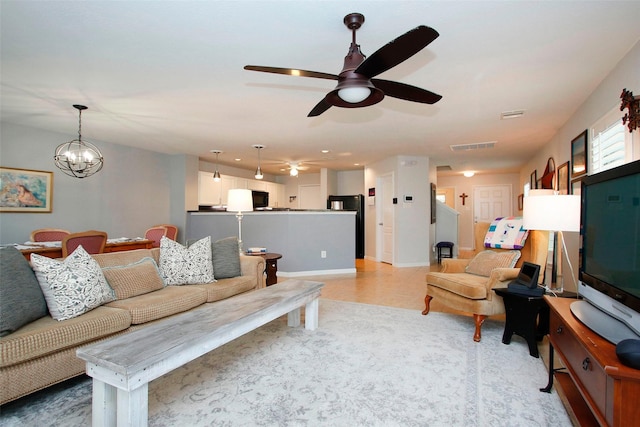 living room with ceiling fan with notable chandelier and visible vents