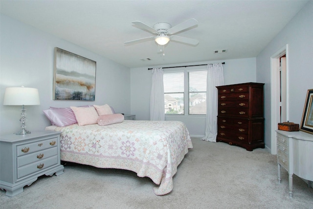 bedroom with visible vents, baseboards, ceiling fan, and light carpet
