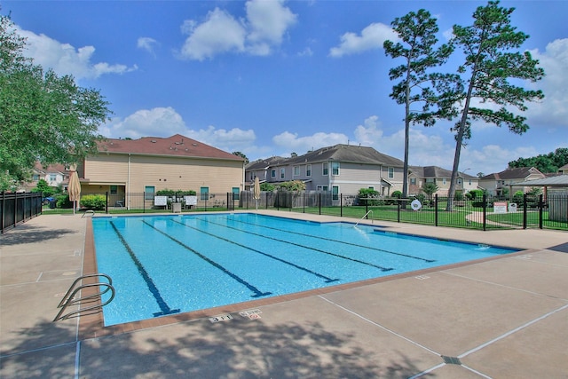 pool with fence and a residential view