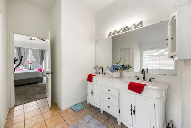 ensuite bathroom with tile patterned flooring, double vanity, baseboards, a sink, and ensuite bath