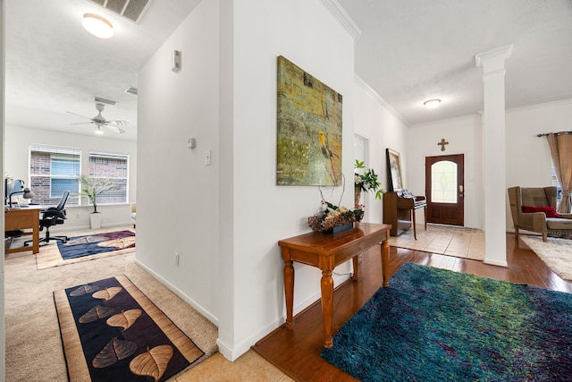 foyer featuring crown molding, decorative columns, a ceiling fan, and wood finished floors