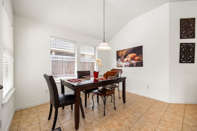 dining area featuring baseboards, light tile patterned floors, and lofted ceiling