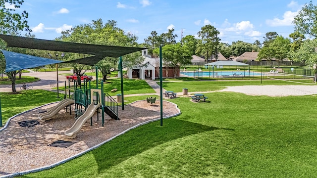 community playground with a lawn, a community pool, and fence