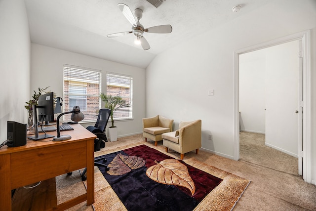 office area featuring a ceiling fan, visible vents, vaulted ceiling, baseboards, and carpet