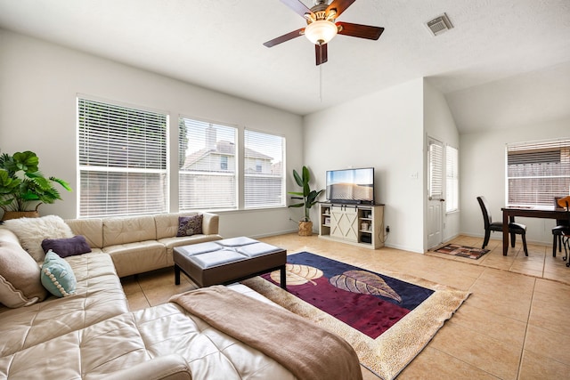 living room featuring visible vents, tile patterned flooring, lofted ceiling, baseboards, and a ceiling fan