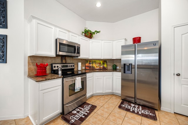 kitchen featuring light tile patterned floors, appliances with stainless steel finishes, tasteful backsplash, and white cabinetry