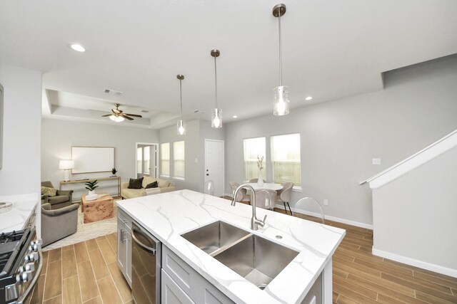 326 Gans St Unit A, Houston, TX 77029 - kitchen with visible vents, wood tiled floor, open floor plan, a sink, and stainless steel appliances