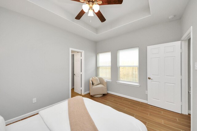 326 Gans St Unit A, Houston, TX 77029 - bedroom with a ceiling fan, baseboards, wood finished floors, and a tray ceiling