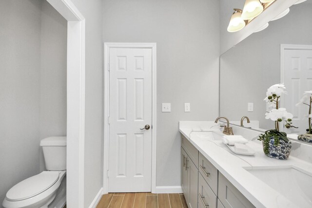 326 Gans St Unit A, Houston, TX 77029 - bathroom with double vanity, wood finished floors, a sink, baseboards, and toilet