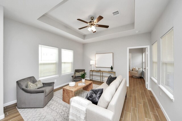 326 Gans St Unit A, Houston, TX 77029 - living area with visible vents, baseboards, wood tiled floor, ceiling fan, and a raised ceiling