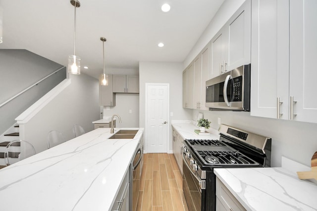 326 Gans St Unit A, Houston, TX 77029 - kitchen featuring light stone counters, a sink, stainless steel appliances, recessed lighting, and wood tiled floor