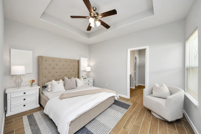 326 Gans St Unit A, Houston, TX 77029 - bedroom featuring a tray ceiling, baseboards, a ceiling fan, and wood finish floors