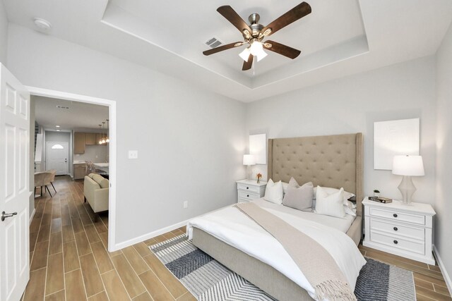 326 Gans St Unit A, Houston, TX 77029 - bedroom featuring a raised ceiling, baseboards, wood finish floors, and visible vents