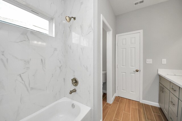 326 Gans St Unit A, Houston, TX 77029 - bathroom featuring vanity, baseboards, wood finished floors,  shower combination, and visible vents