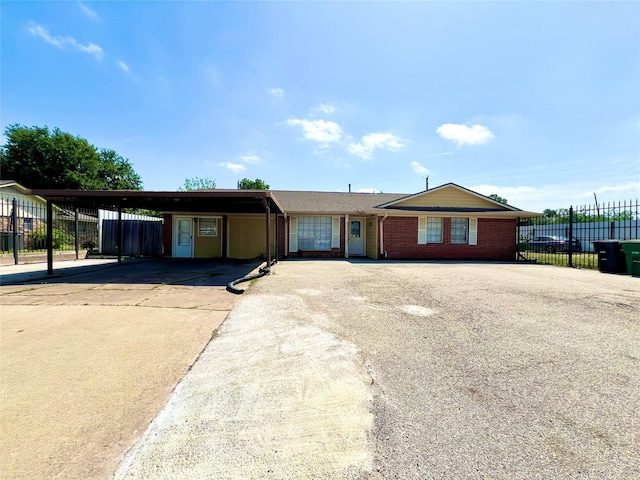 single story home with brick siding, aphalt driveway, fence, and a carport
