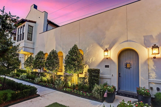entrance to property featuring stucco siding