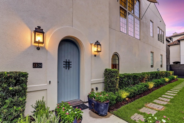 entrance to property featuring stucco siding